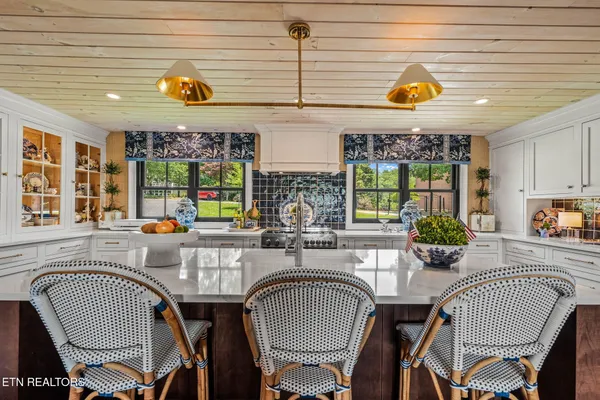 a kitchen with a stove a sink a dining table and chairs