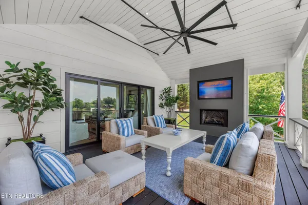 a living room with furniture a fireplace a large window and a potted plant