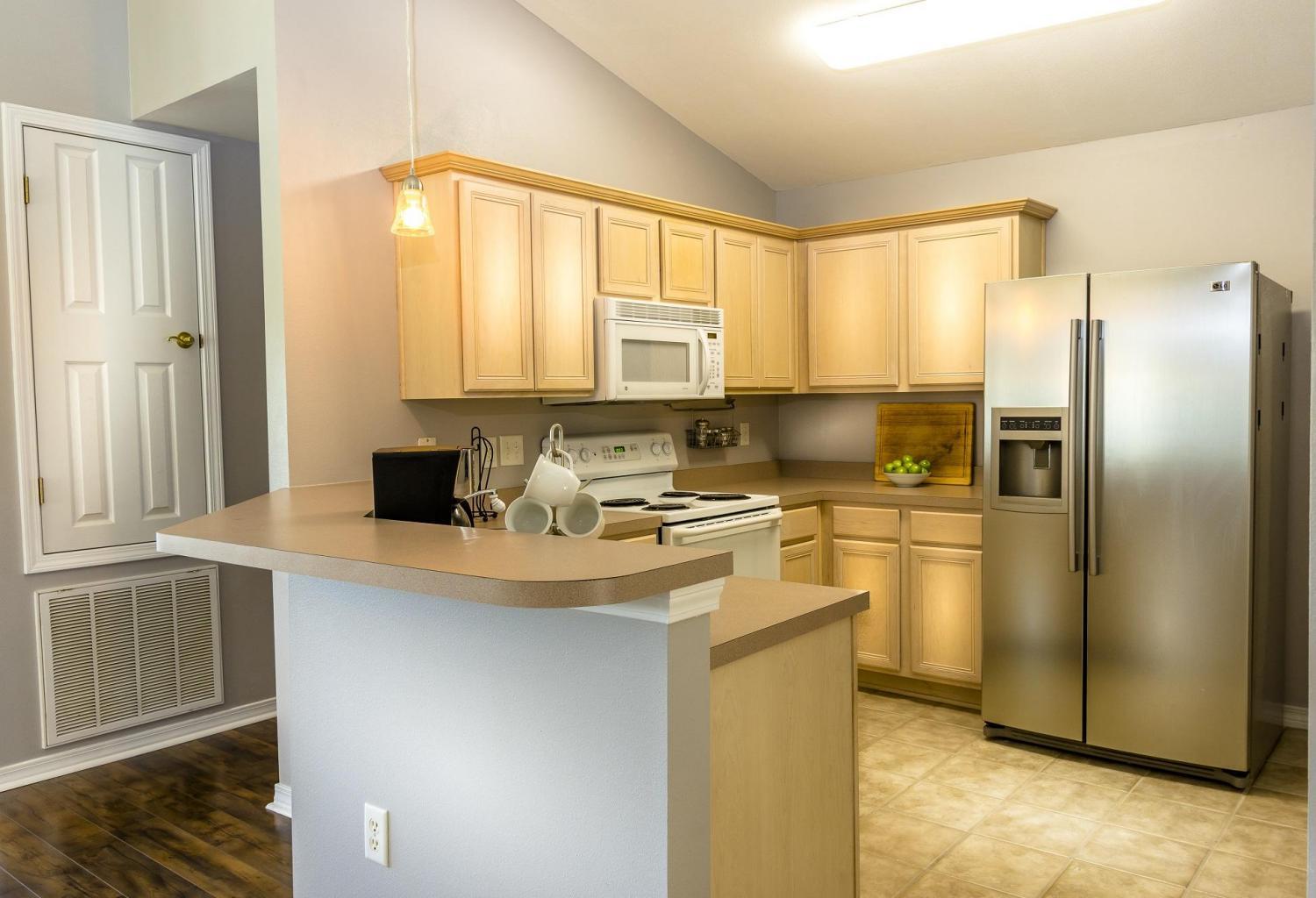 235 South Harborview Road Santa Rosa Beach, FL 32459 - Photo 6 of 12 a kitchen with stainless steel appliances granite countertop a refrigerator a stove and a sink with wooden floor