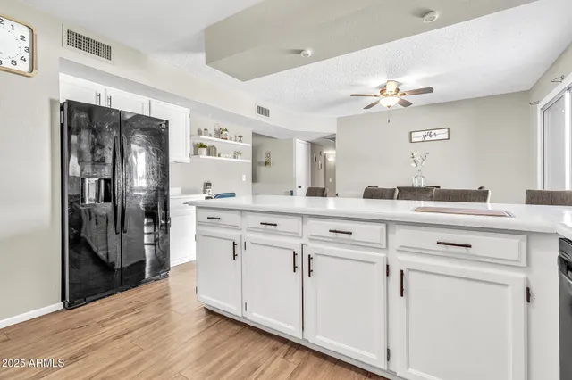 a kitchen with stainless steel appliances a refrigerator and a wooden floor