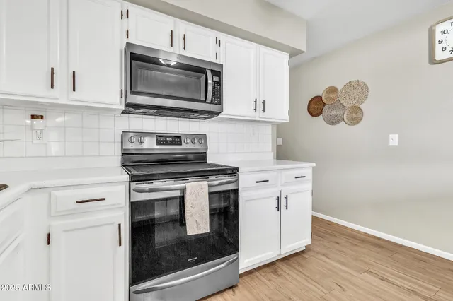 a spacious bathroom with a granite countertop sink a toilet a mirror and shower