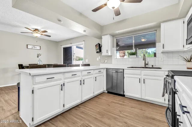 a kitchen with stainless steel appliances white cabinets and wooden floors
