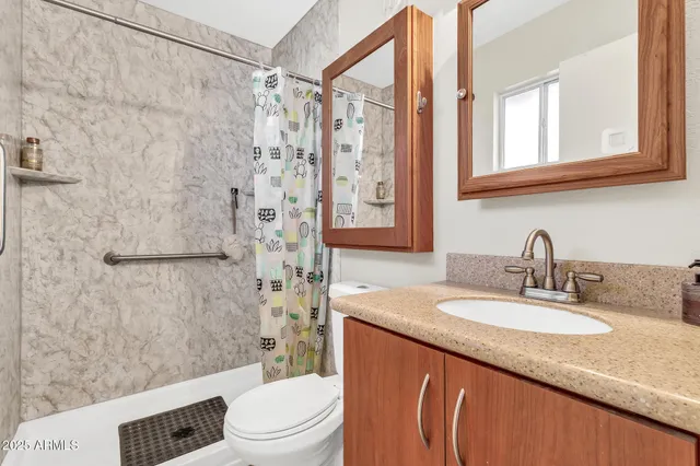 a kitchen with stainless steel appliances granite countertop a dining table chairs refrigerator and microwave