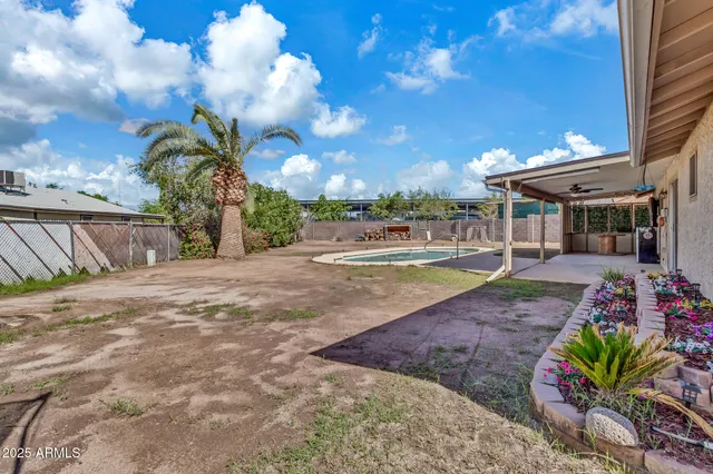 a view of a house with backyard and sitting area