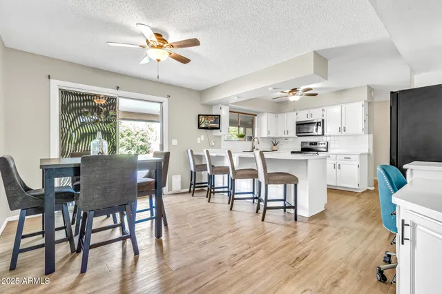 a dining room with furniture a chandelier and wooden floor