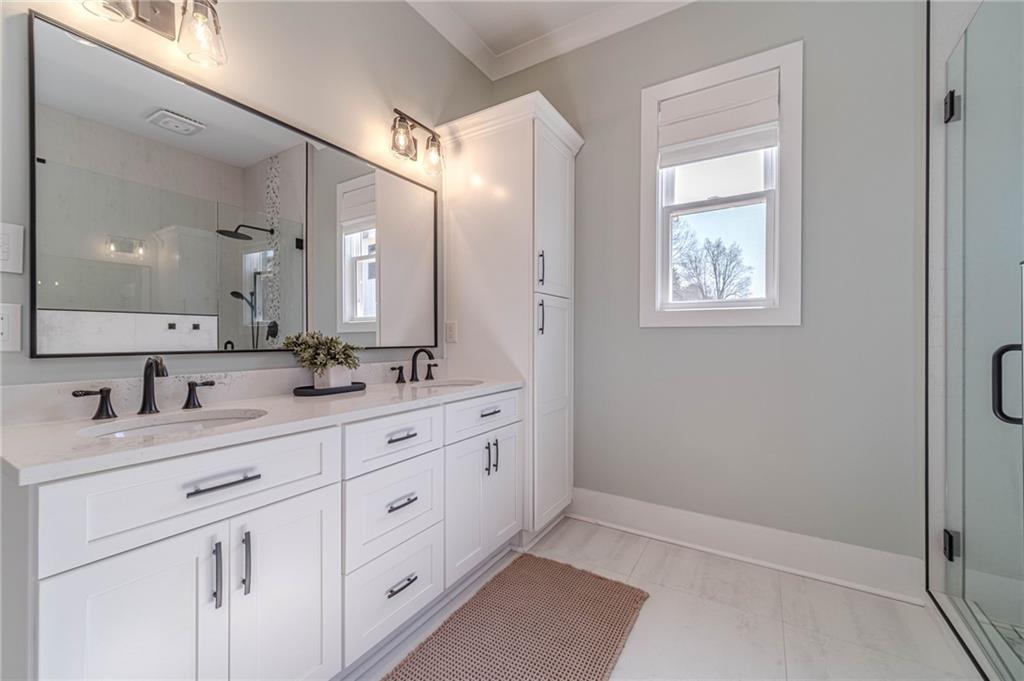 1009 Easy Street Winder, GA 30680 - Photo 24 of 78 a bathroom with a double vanity sink and a mirror