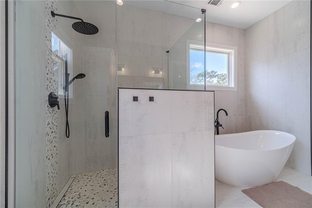1009 Easy Street Winder, GA 30680 - Photo 26 of 78 a bathroom with a white tub shower and sink