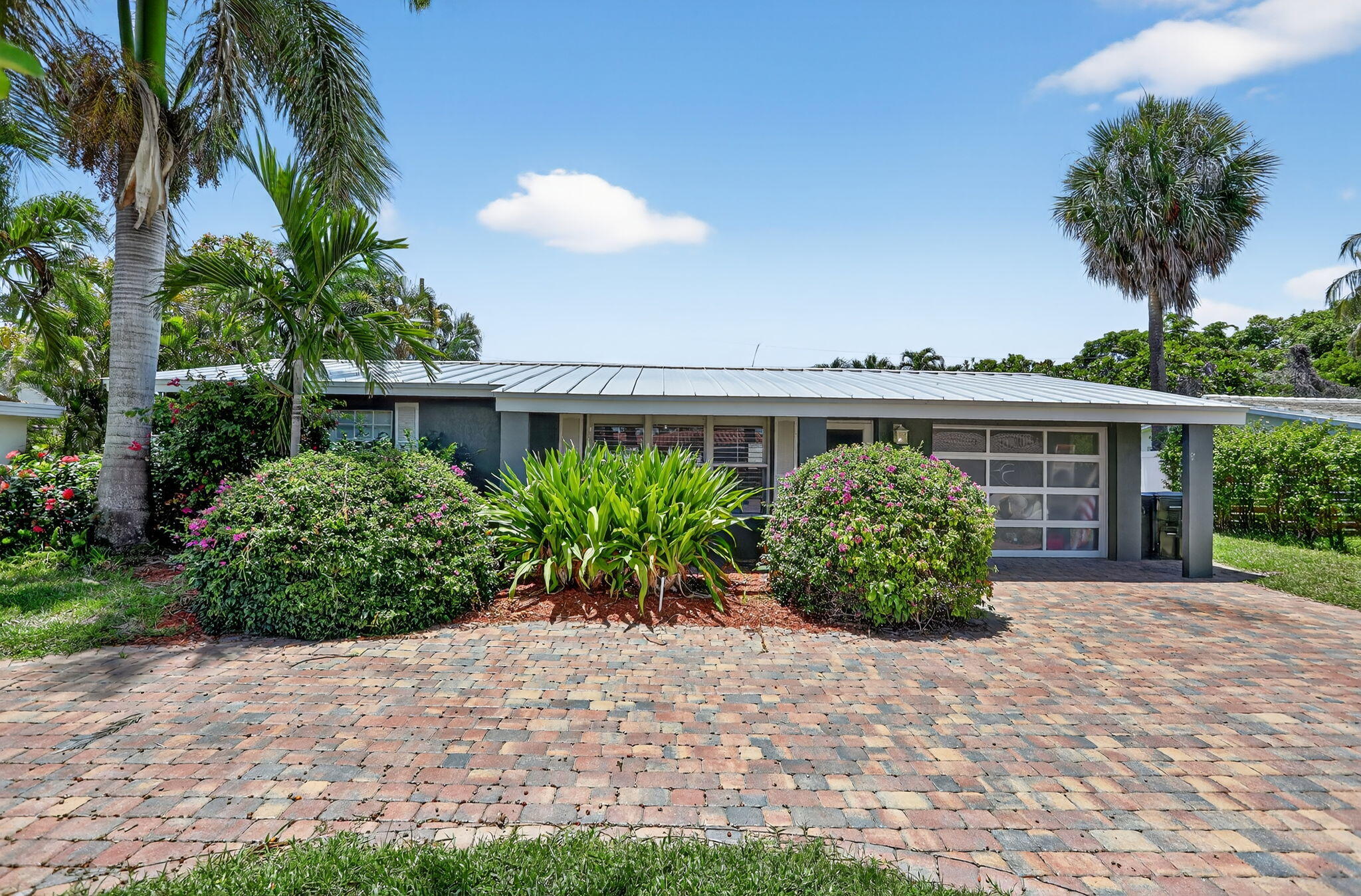 1960 Northeast 31st Street Lighthouse Point, FL 33064 - Photo 2 of 27 a front view of a house with garden