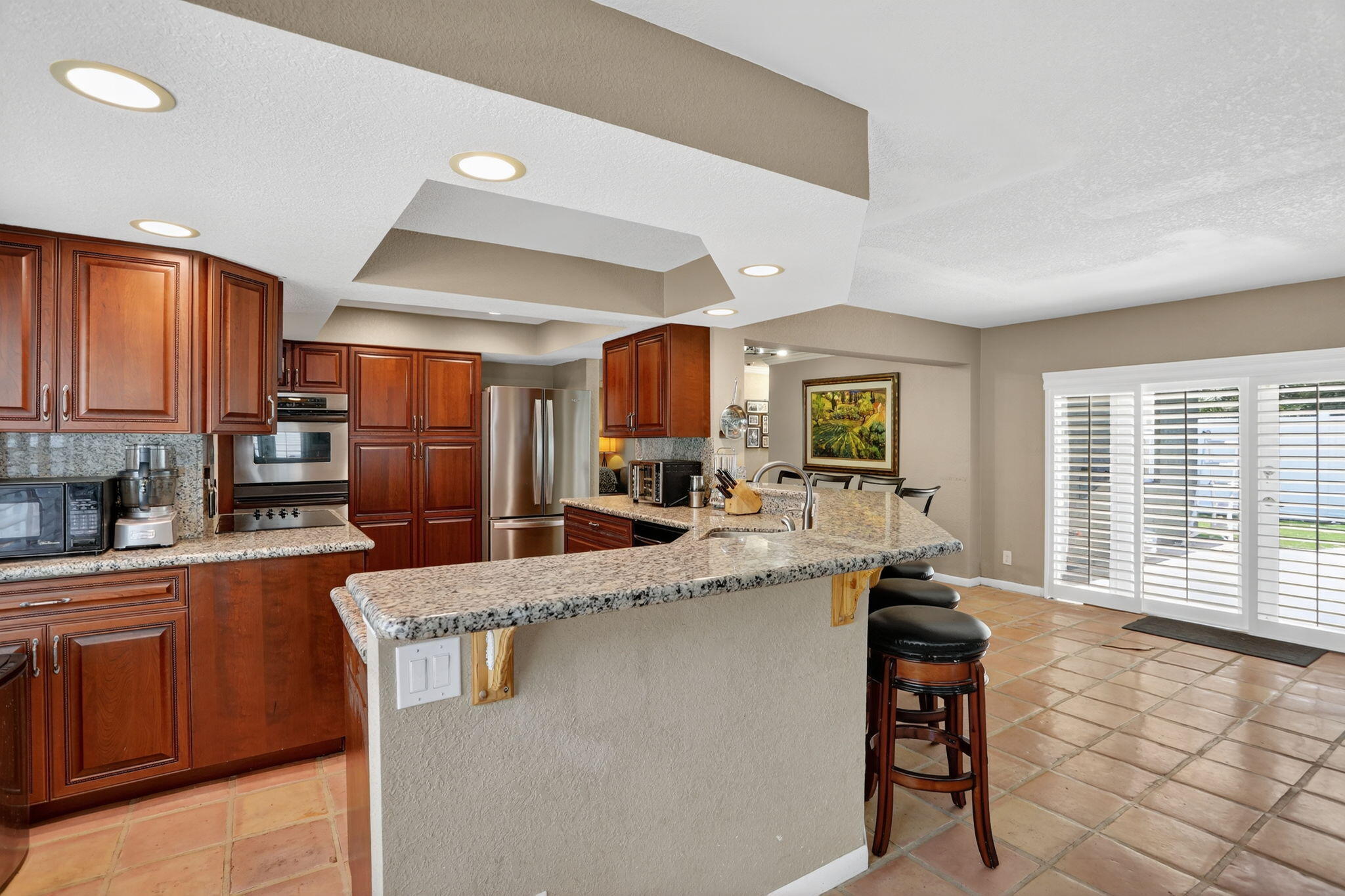 1960 Northeast 31st Street Lighthouse Point, FL 33064 - Photo 3 of 27 a living room with stainless steel appliances kitchen island granite countertop a table chairs in it and a window