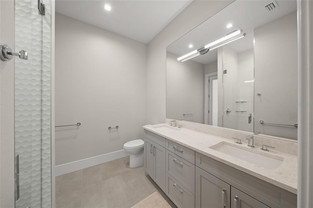 4050 Camino Real Sarasota, FL 34231 - Photo 32 of 59 a bathroom with a double vanity sink toilet and shower