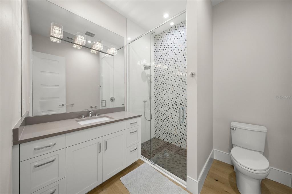 4050 Camino Real Sarasota, FL 34231 - Photo 36 of 59 a bathroom with a granite countertop sink a toilet a mirror and shower