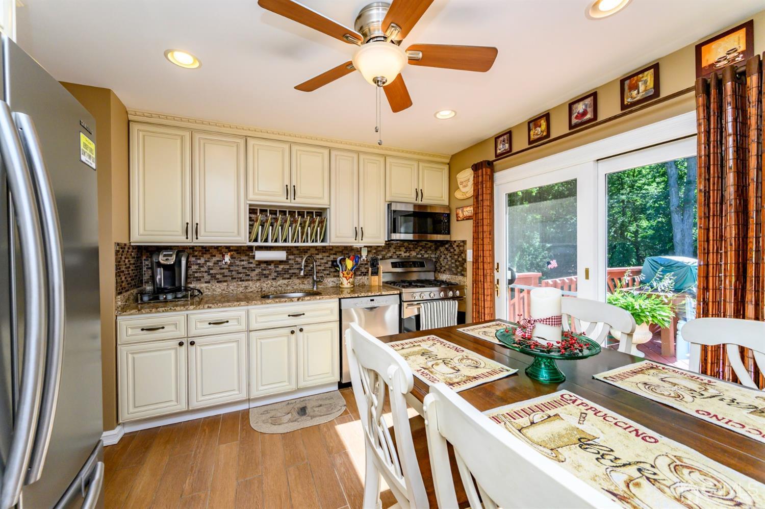 8 Warwick Road Edison, NJ 08820 - Photo 40 of 51 a kitchen with stainless steel appliances granite countertop a stove a sink dishwasher a refrigerator white cabinets and wooden floor