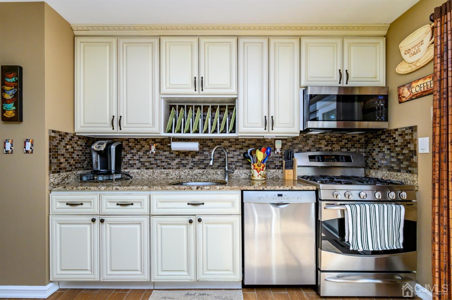 8 Warwick Road Edison, NJ 08820 - Photo 42 of 51 a kitchen with stainless steel appliances granite countertop a stove a sink and a microwave