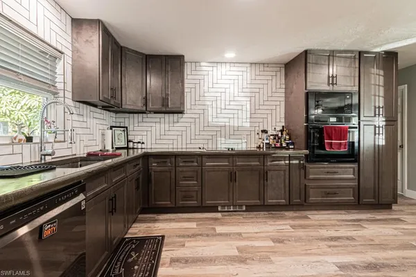 a kitchen with stainless steel appliances granite countertop a sink stove and cabinets