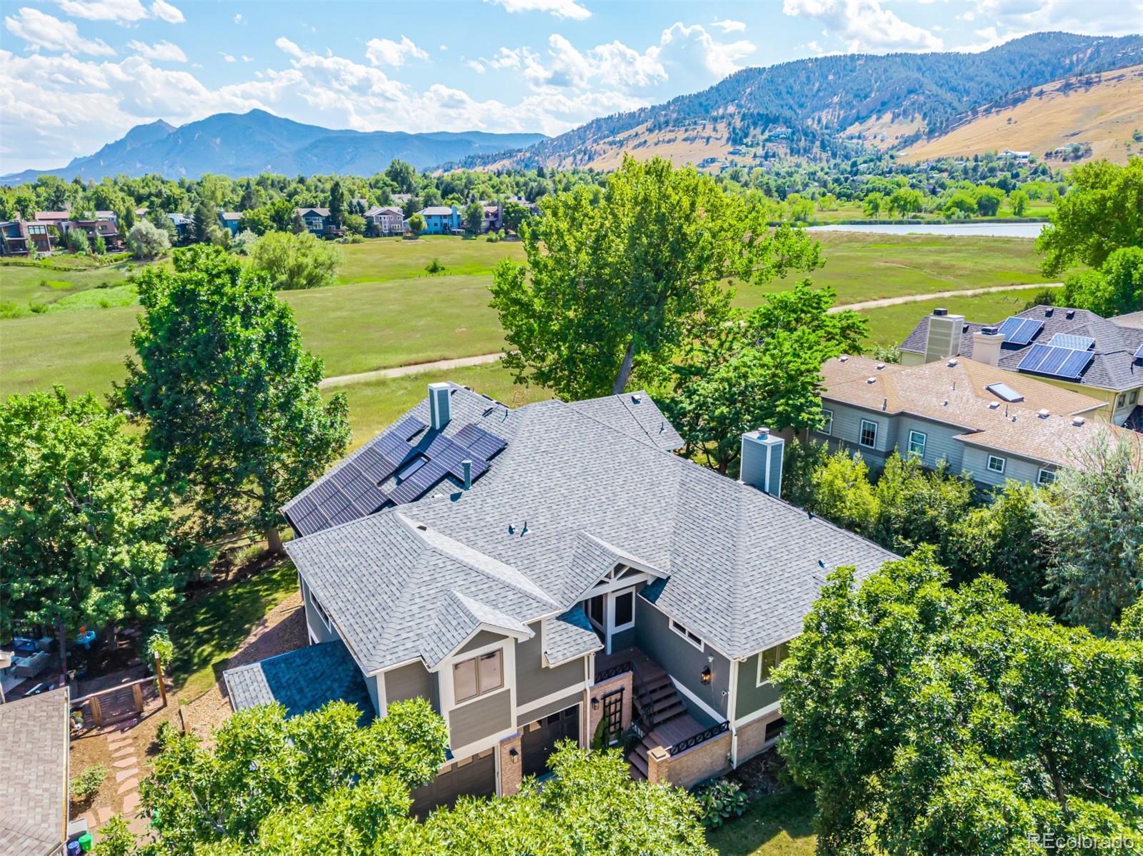 an aerial view of a house with a garden and lake view