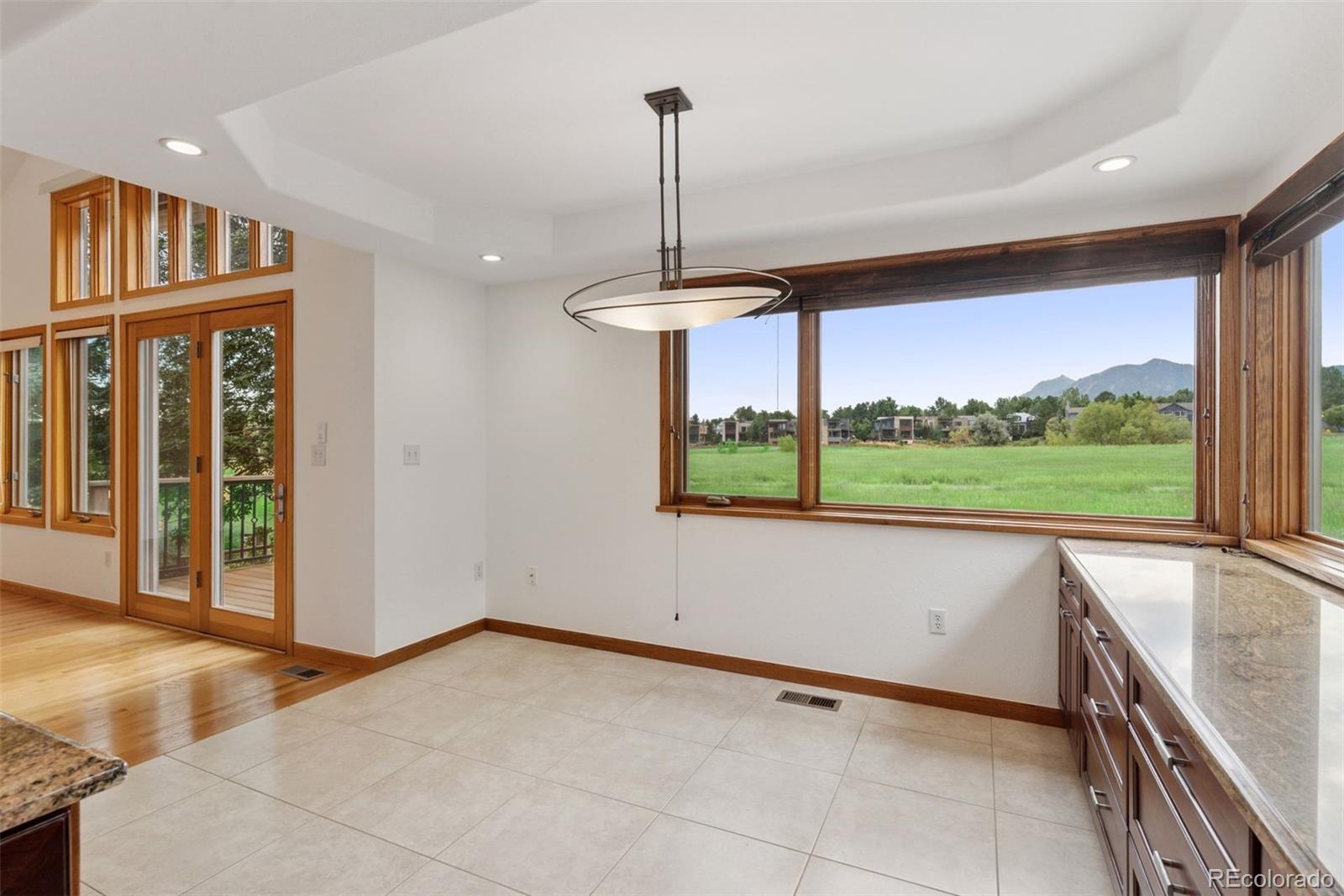 990 Utica Circle Boulder, CO 80304 - Photo 17 of 48 a view of an empty room with window wooden floor and a kitchen view