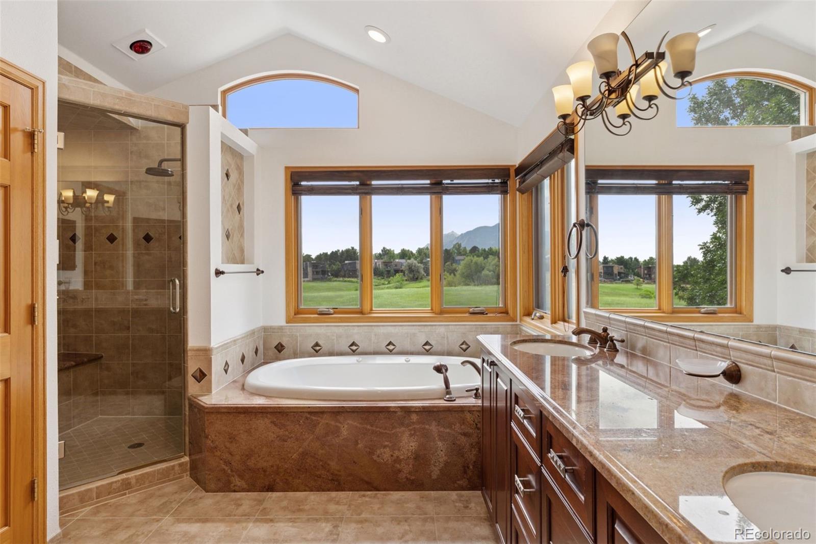990 Utica Circle Boulder, CO 80304 - Photo 28 of 48 a bathroom with a granite countertop tub sink and mirror