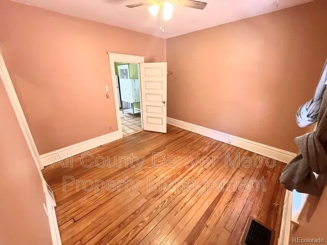 a view of empty room with wooden floor