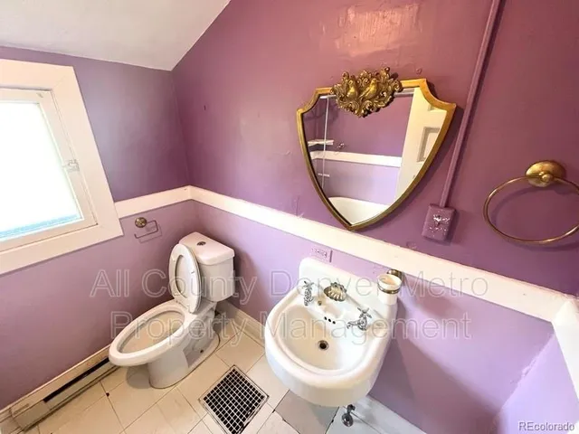 a bathroom with a toilet mirror and sink
