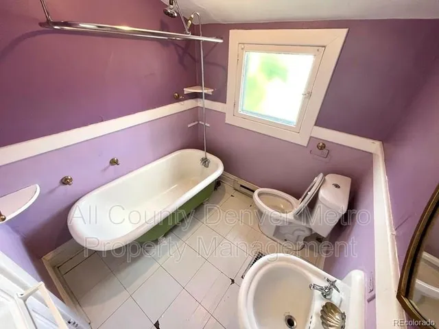 a view of a house with a small yard and large tree