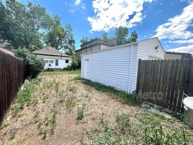 a view of backyard of house with green space