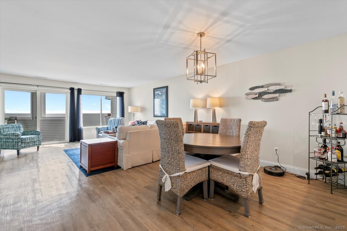 1 Mansfield Grove Road, Unit 206 East Haven, CT 06512 - Photo 13 of 40 a dining room with wooden floor a chandelier a glass table and chairs