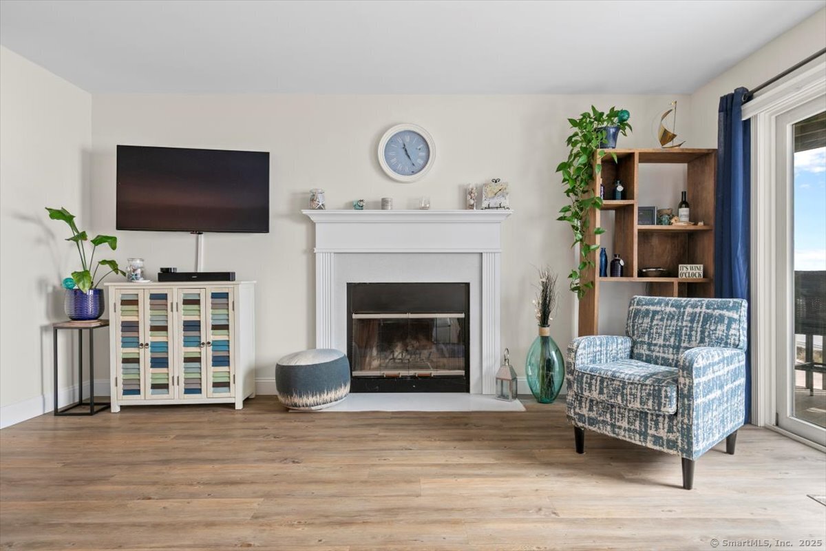 1 Mansfield Grove Road, Unit 206 East Haven, CT 06512 - Photo 14 of 40 a living room with furniture a flat screen tv and a fireplace
