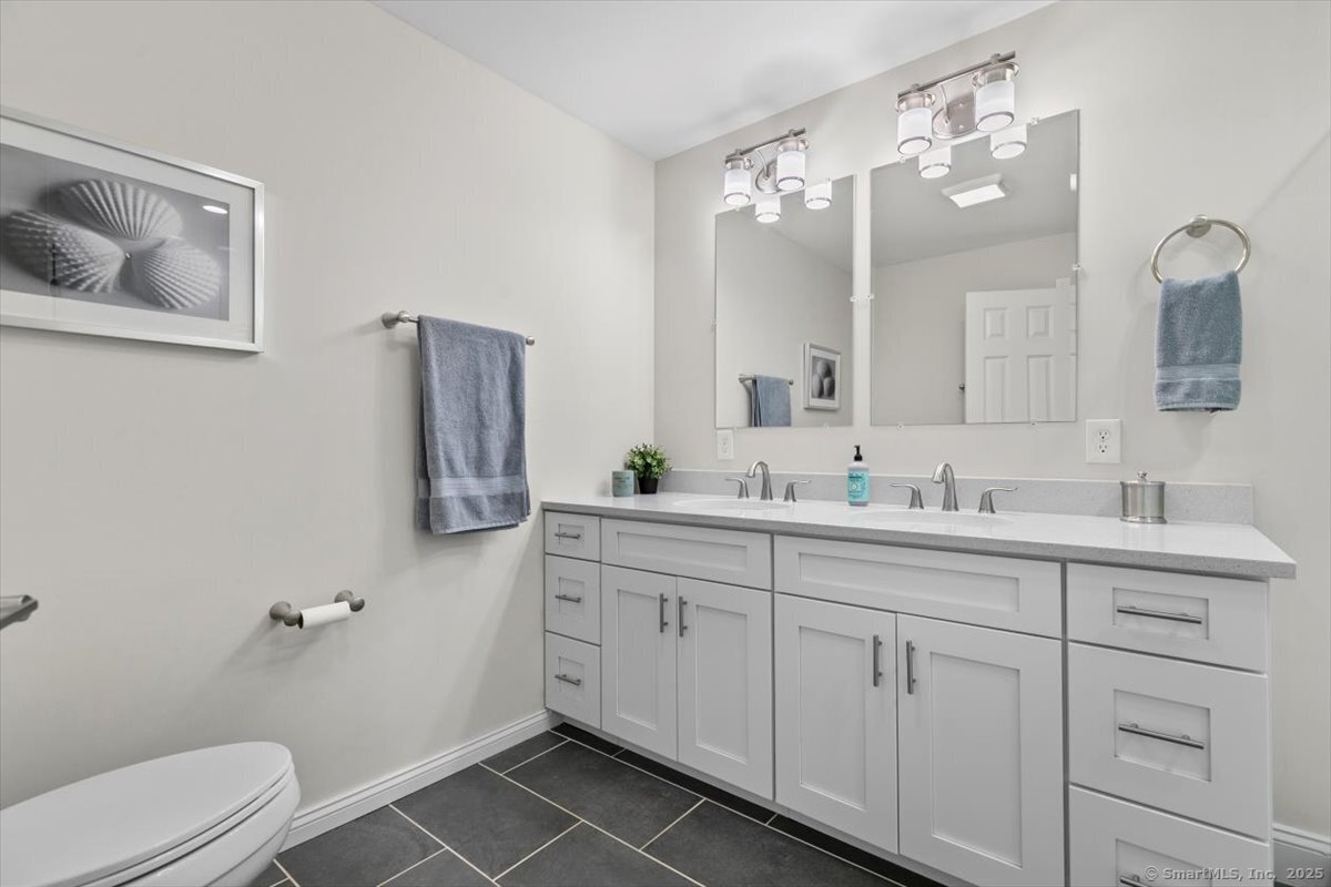 1 Mansfield Grove Road, Unit 206 East Haven, CT 06512 - Photo 21 of 40 a bathroom with a double vanity sink mirror and toilet