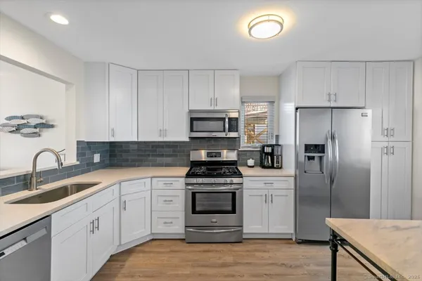 a kitchen with granite countertop a refrigerator stove and sink