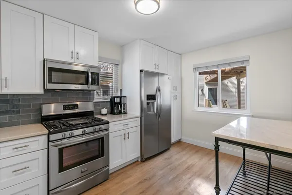 a kitchen with stainless steel appliances a stove microwave and sink
