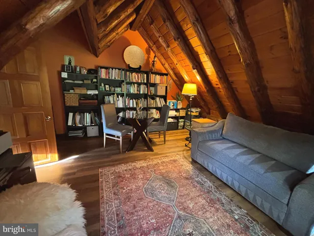 a view of an empty room with wooden floor and stairs