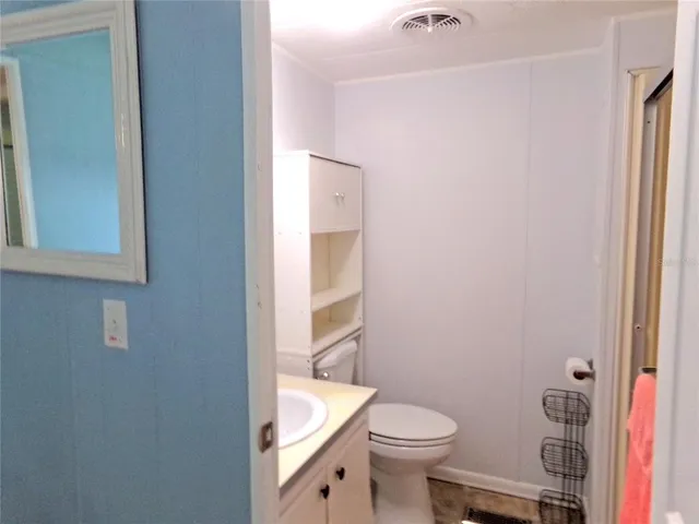 a white toilet sitting next to a bathroom sink and vanity
