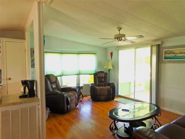 a living room with furniture a table and a large window