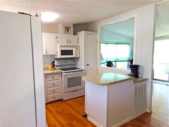 a kitchen with granite countertop a sink stove and refrigerator