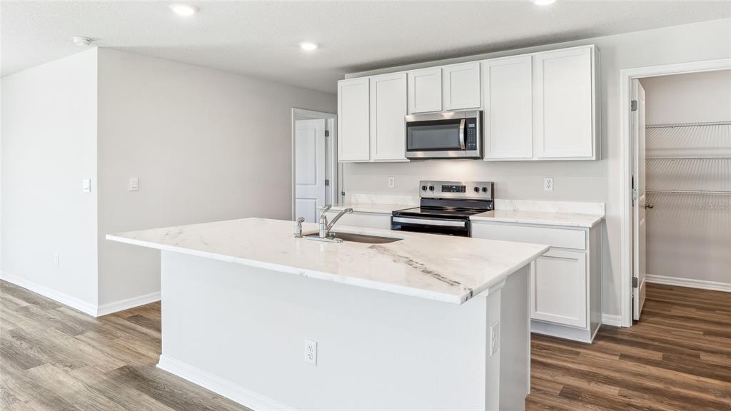 18125 Gander Terrace Lakewood Ranch, FL 34211 - Photo 5 of 50 a kitchen with a sink a stove and refrigerator