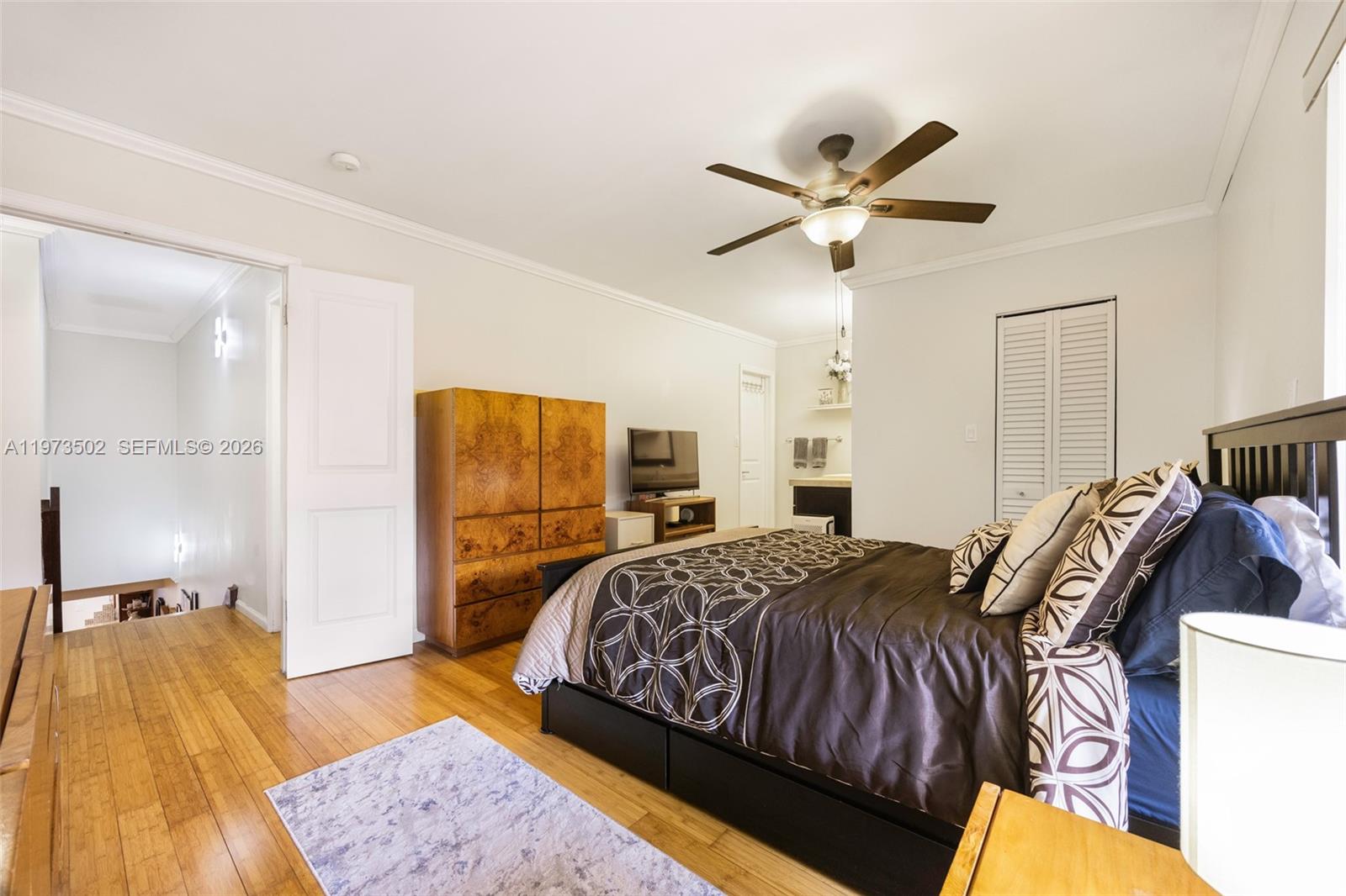 11353 Southwest 109th Road, Unit 55X Miami, FL 33176 - Photo 15 of 26 a bedroom with a bed and a chandelier