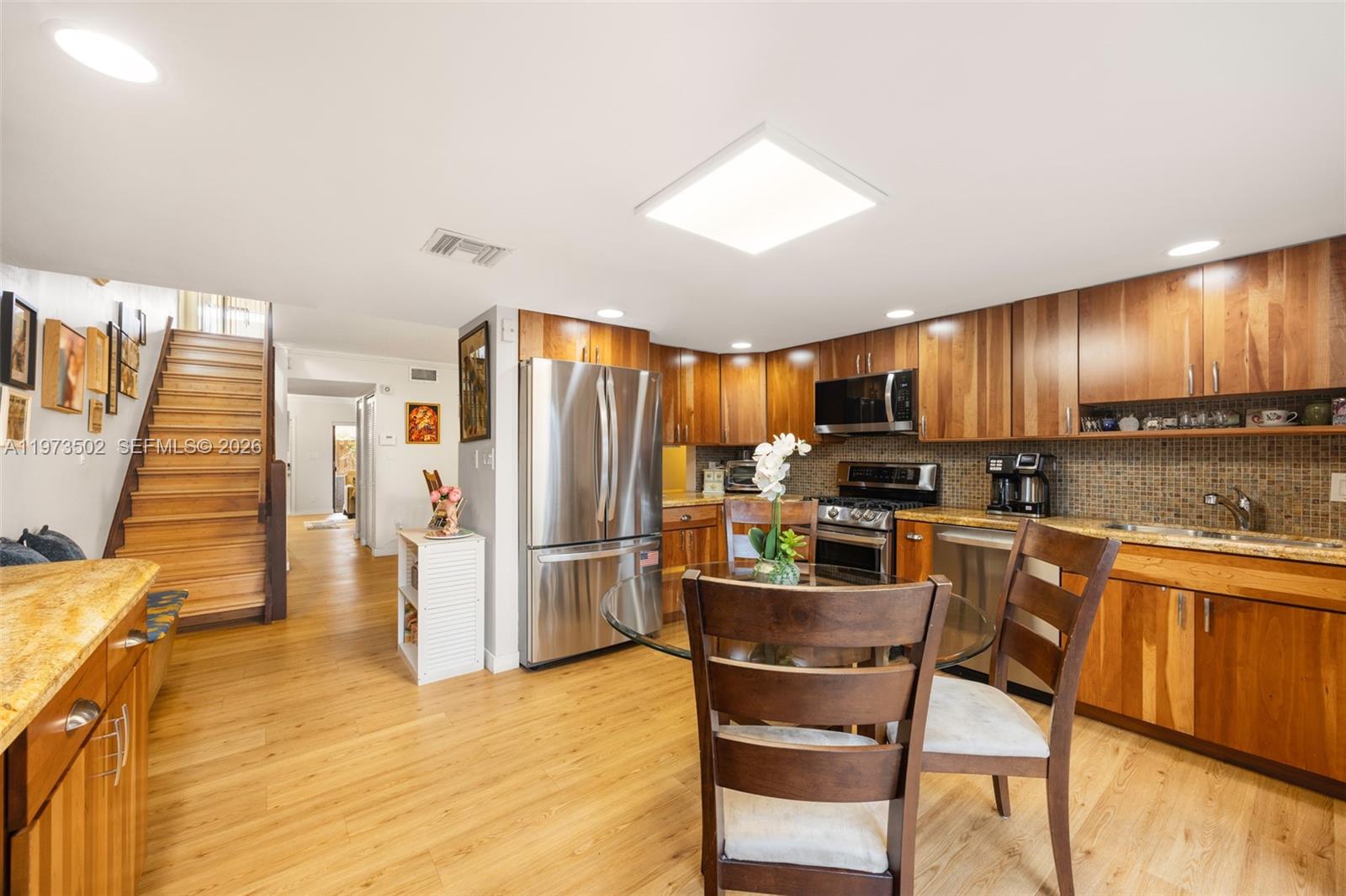 11353 Southwest 109th Road, Unit 55X Miami, FL 33176 - Photo 9 of 26 a kitchen with refrigerator cabinets dining table and chairs