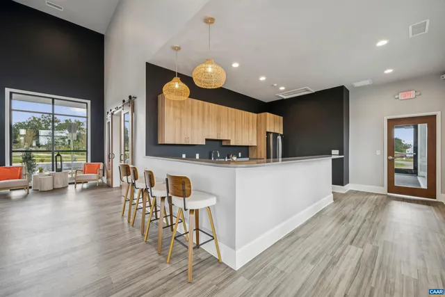 a kitchen with kitchen island granite countertop a sink a counter space appliances and cabinets