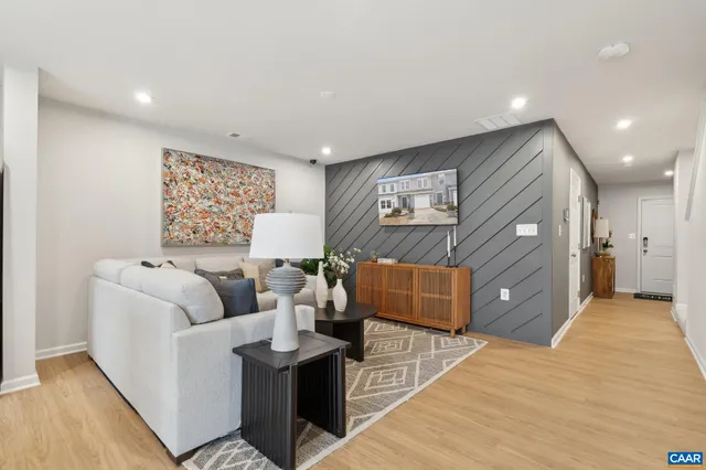 a living room with furniture and a wooden floor