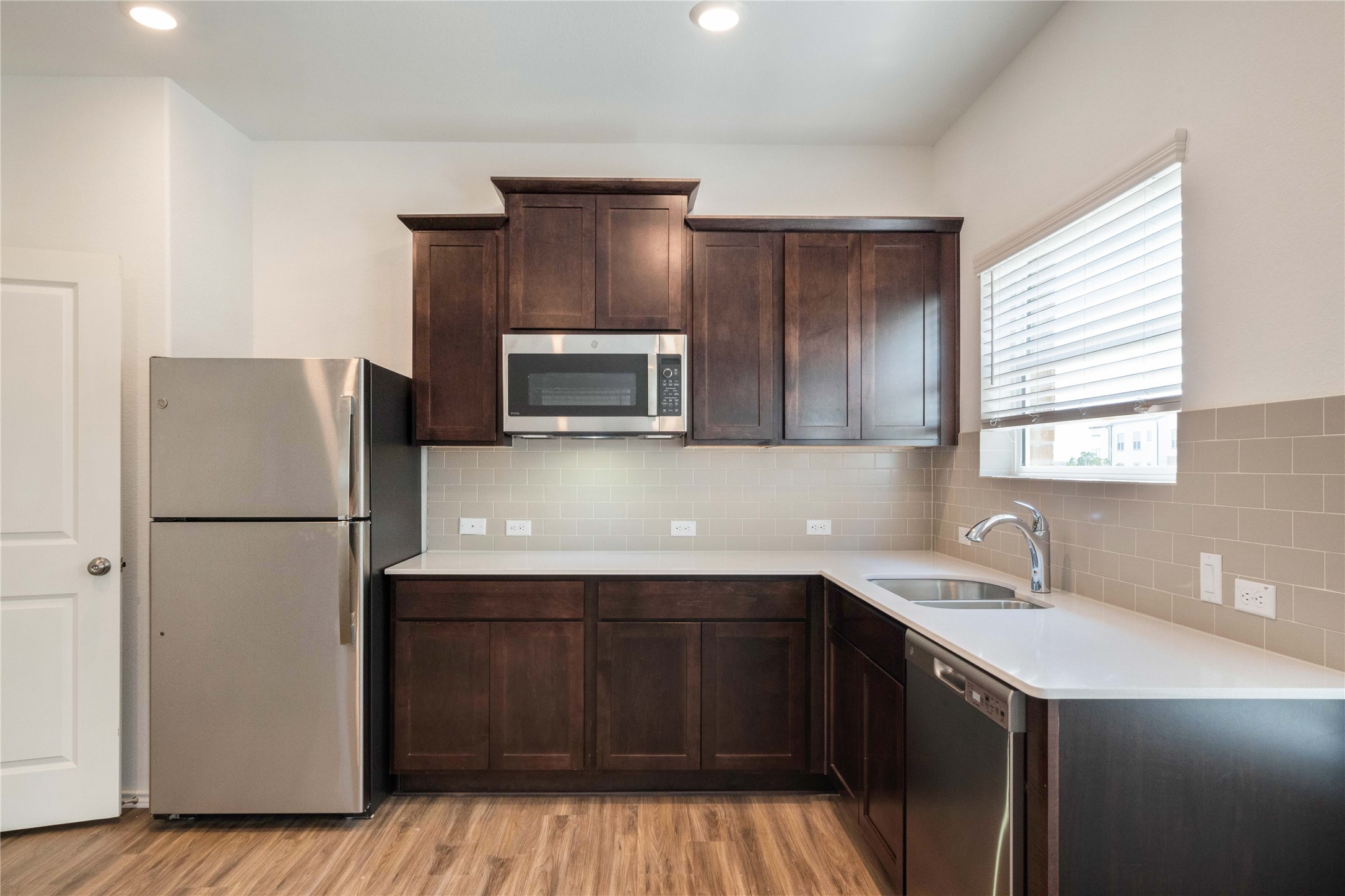 932 Mallow Road Leander, TX 78641 - Photo 25 of 40 a kitchen with a sink a refrigerator and wooden cabinets