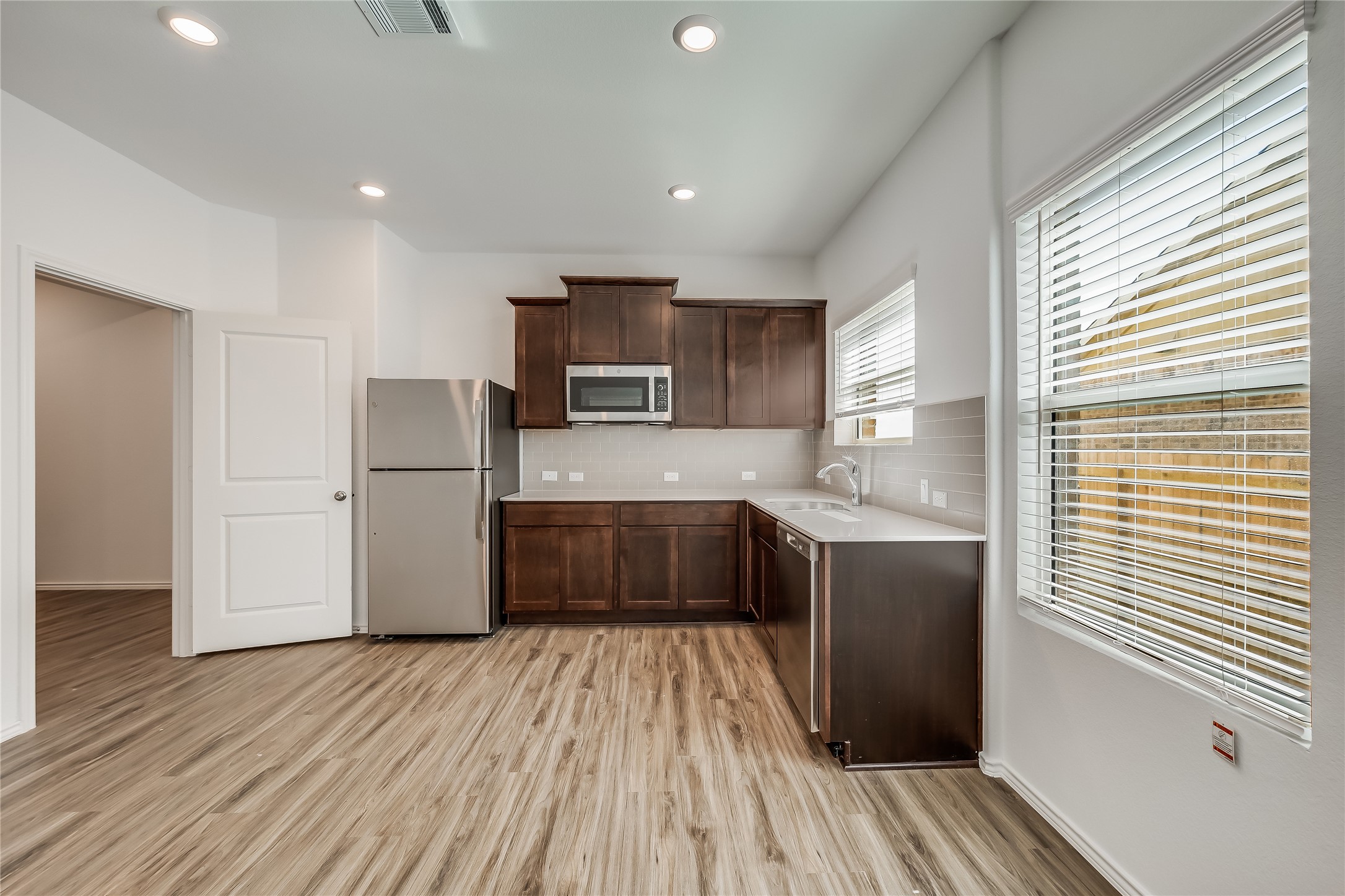 932 Mallow Road Leander, TX 78641 - Photo 27 of 40 a kitchen with refrigerator cabinets and wooden floor
