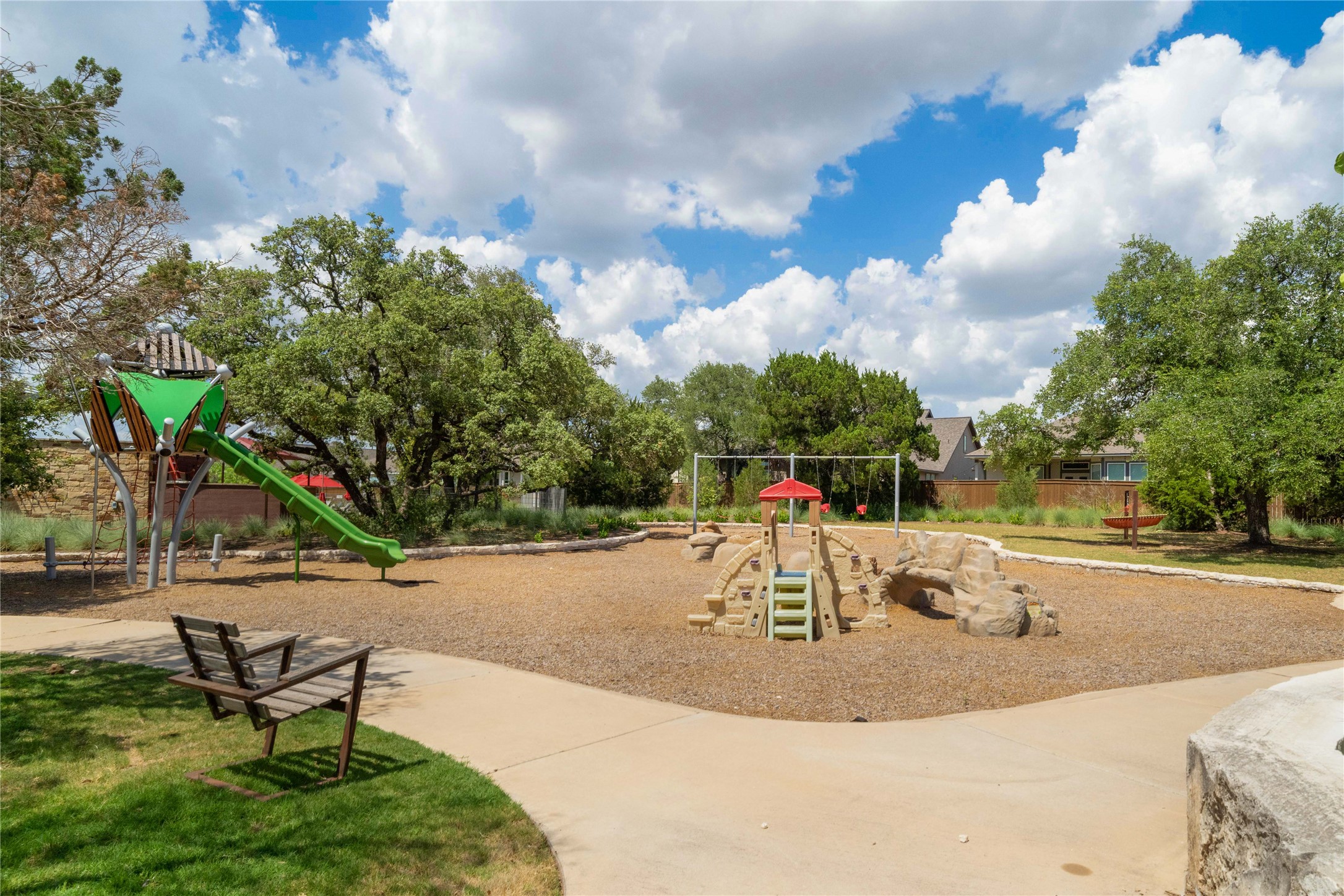 932 Mallow Road Leander, TX 78641 - Photo 33 of 40 Community playground featuring a green slide, rock climbing structures, and swing sets