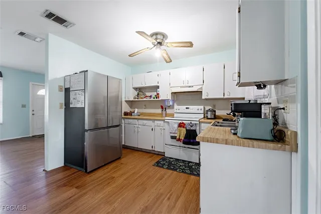 a kitchen with refrigerator cabinets and wooden floor