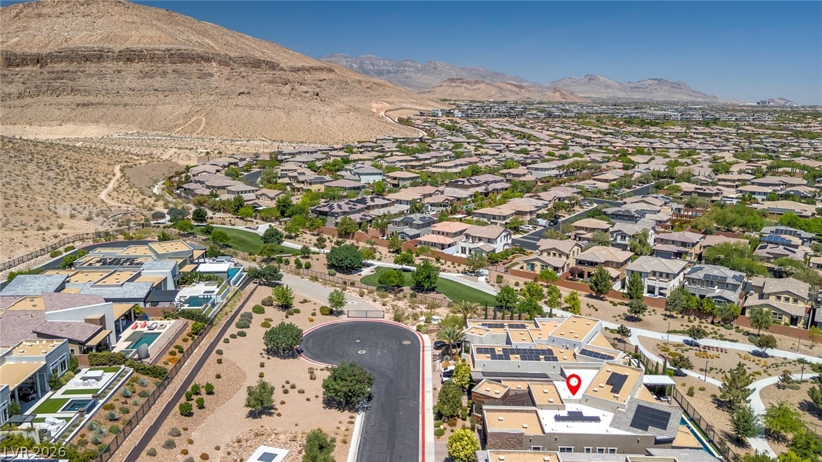6014 Willow Ridge Court Las Vegas, NV 89135 - Photo 86 of 99 An aerial view showcases a residential community nestled among arid mountains under a bright sky.