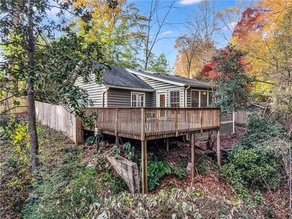 a view of a house with a yard and wooden deck
