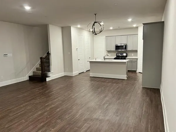 a large kitchen with cabinets wooden floor and stainless steel appliances