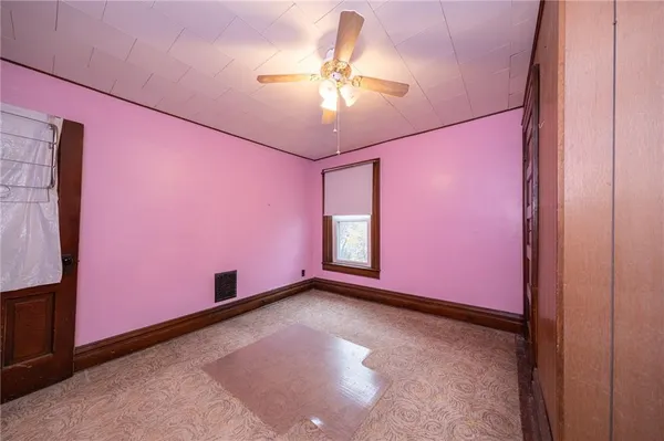 a view of an empty room with a chandelier fan
