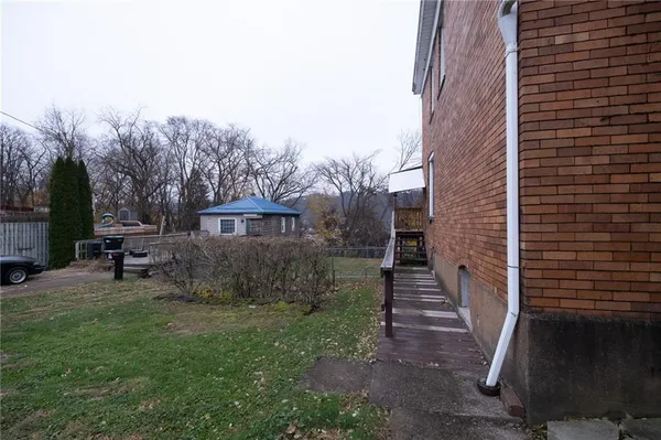 a view of a house with a yard and stairs