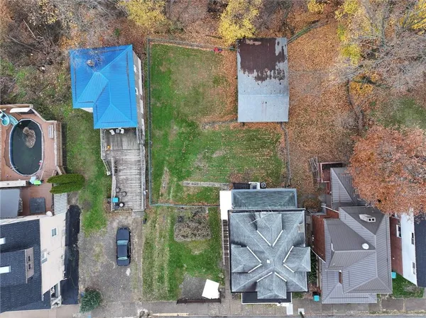 an aerial view of residential houses with outdoor space and parking