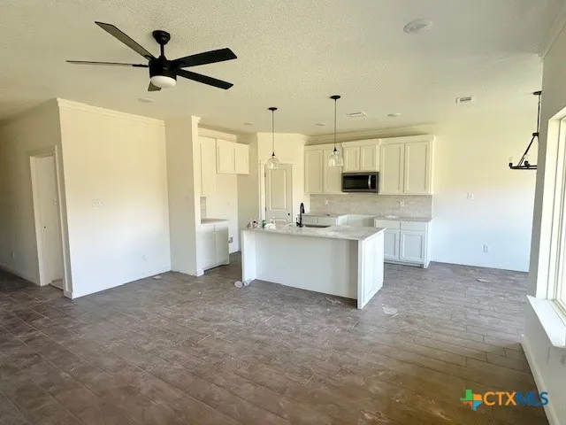 a view of a kitchen with a sink and a refrigerator